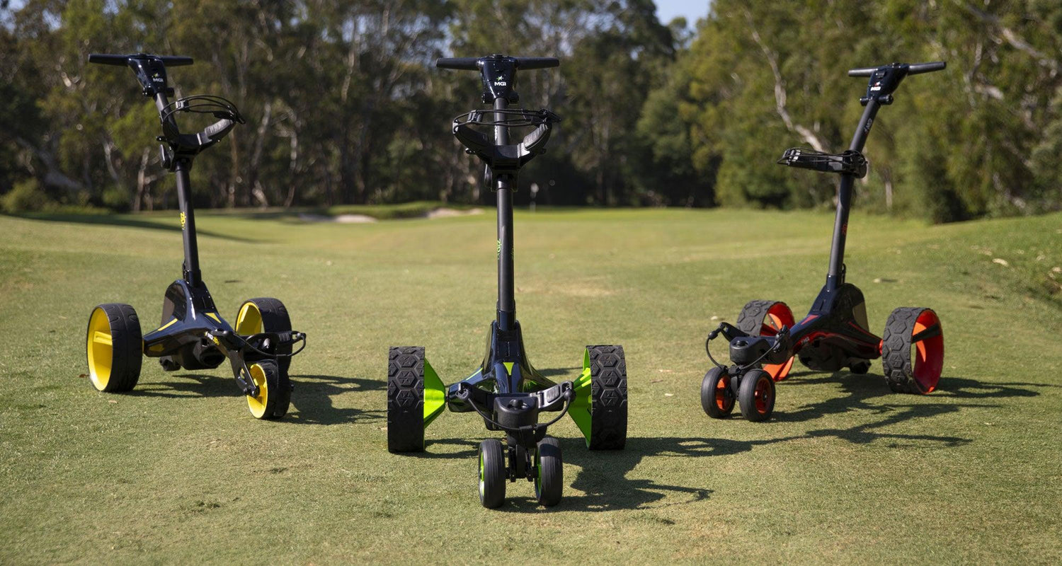 Three MGI electric golf buggies with colored wheels on a golf course, Hillside Buggies